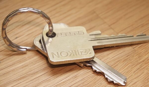 A set of metal house keys on a wooden surface, ideal for real estate themes.